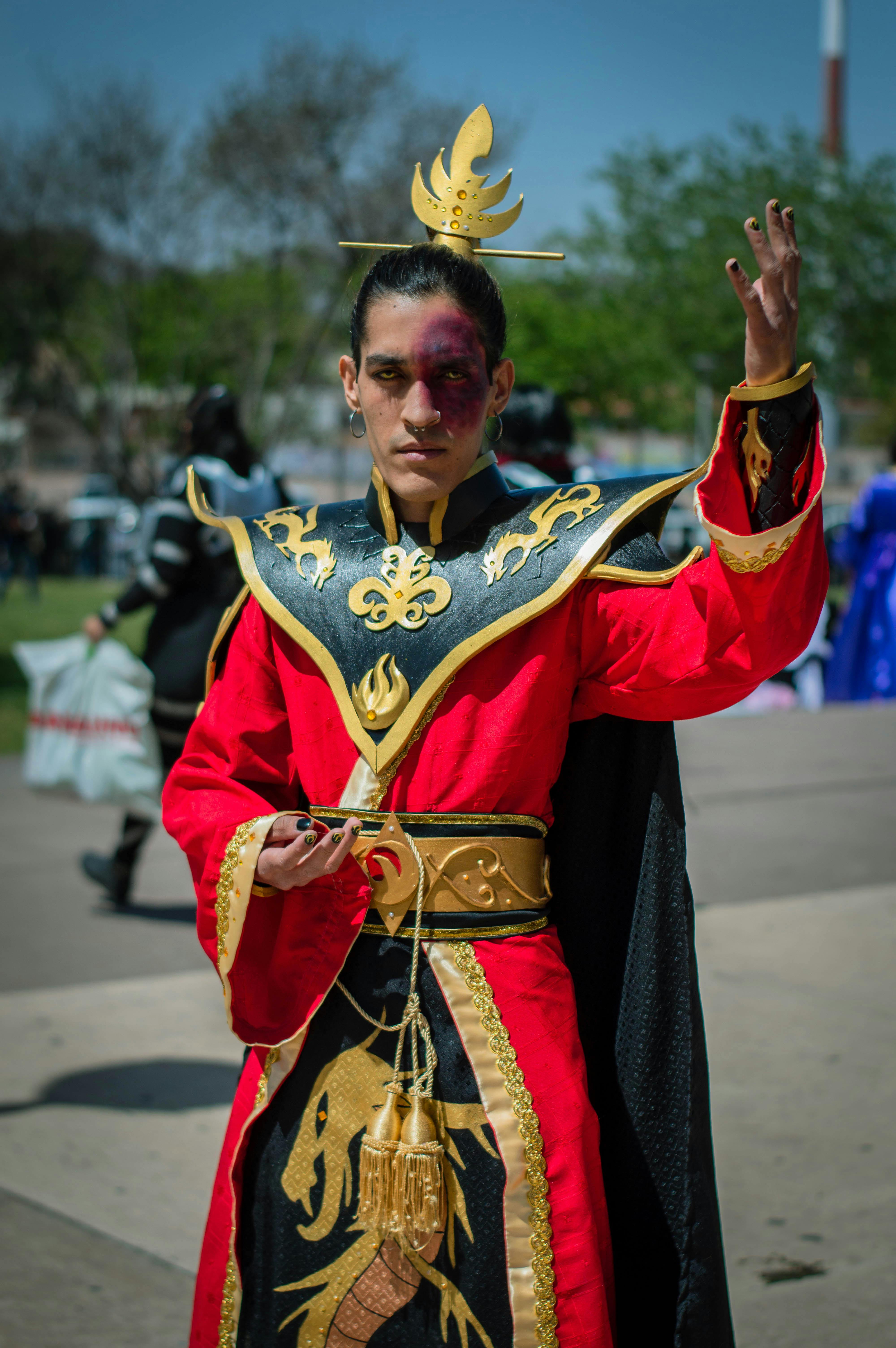 Adult male in detailed cosplay costume posing confidently outdoors during daytime.