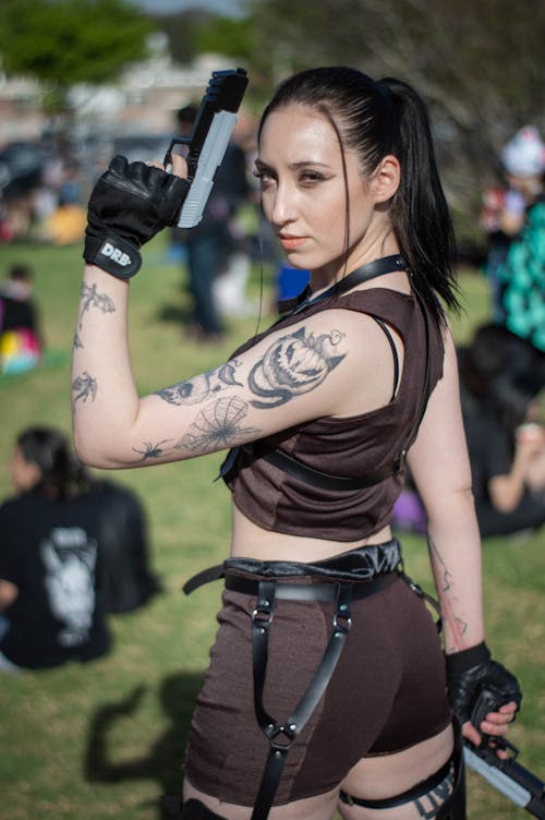 A Woman with Arm Tattoo Holding Pistols