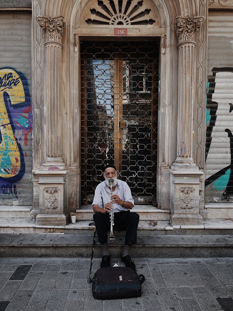 Busker Playing Trumpet Near Door