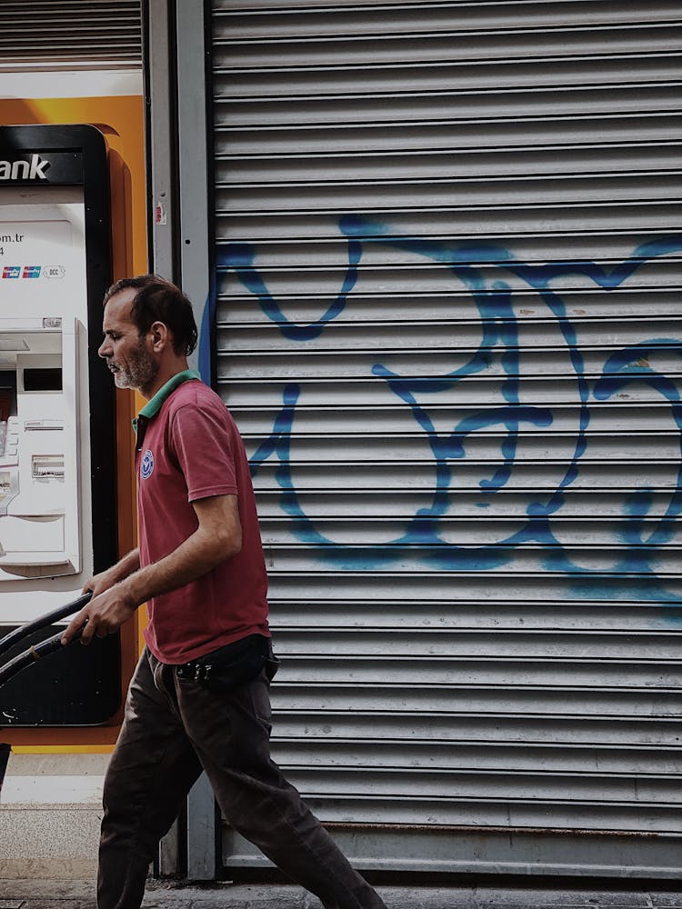 Candid Picture Of A Man Walking By A Wall With Graffiti 