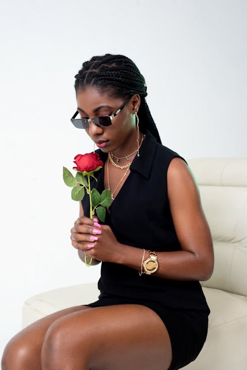 Gratis stockfoto met aan hebben, Afro-Amerikaanse vrouw, bloem vasthouden