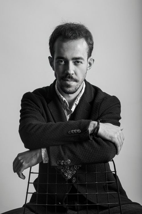 Free Black and white portrait of a man posing elegantly in a tuxedo during a studio photoshoot. Stock Photo