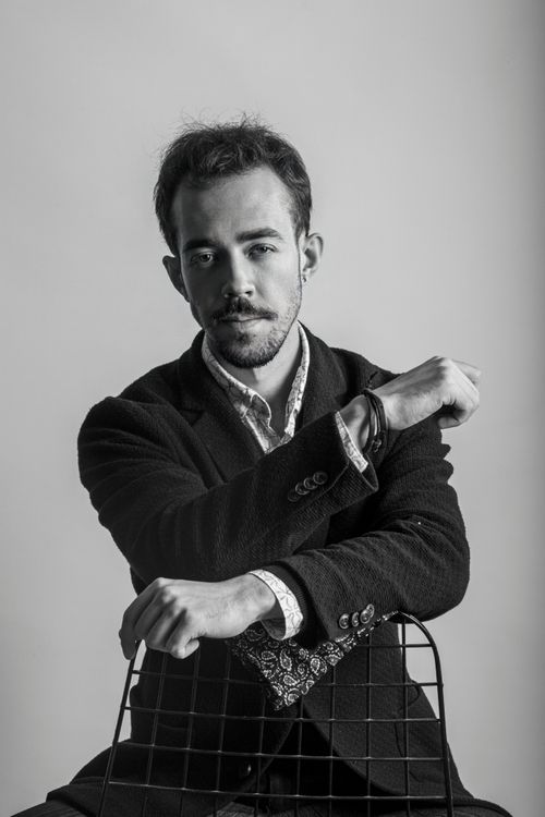 Free Artistic black and white portrait of a fashionable man posing in a suit during a studio shoot. Stock Photo