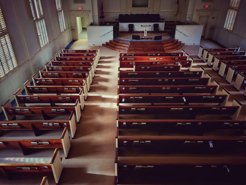 Sunlit church sanctuary with wooden pews and altar