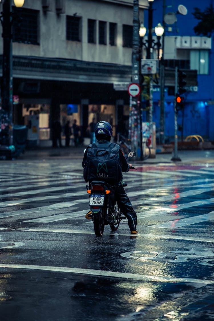 Man Riding A Scooter In A City 