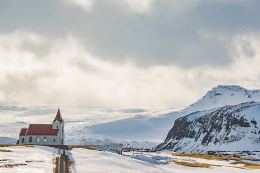 White Cathedral Near Mountain Covered With Snow