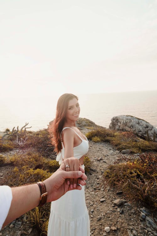 Man Holding Woman Hand with Engagement Ring