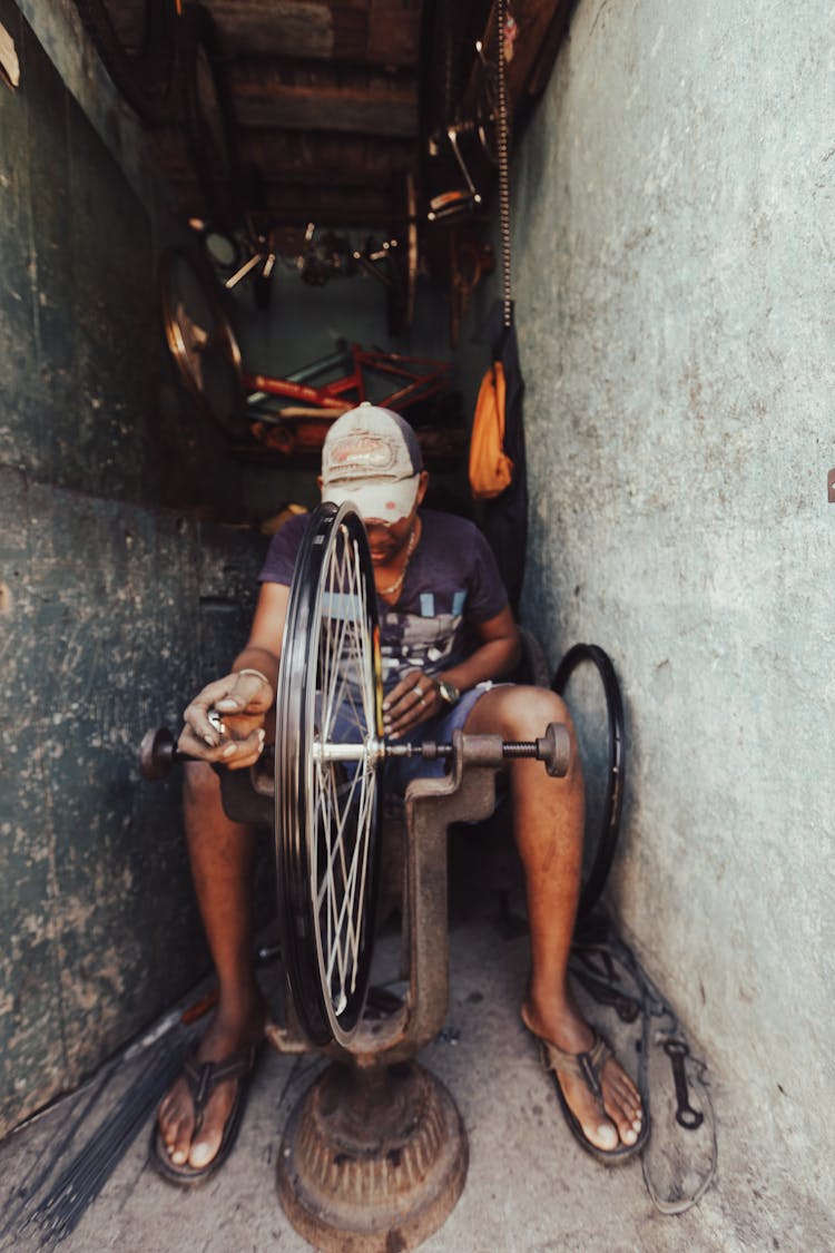 Man Fixing Wheel Of A Bicycle