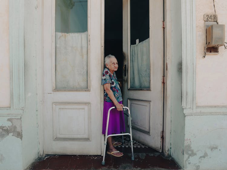 Elderly Woman Standing In Doorway