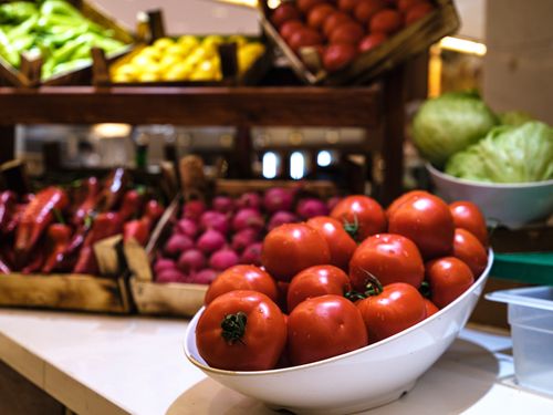 Free Close-up view of fresh tomatoes arranged with other vegetables in a market setting, highlighting organic produce. Stock Photo
