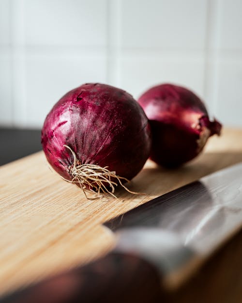 Close-Up Shot of Onions on Wooden Chopping Board 