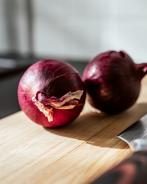 Close-Up Shot of Onions on Wooden Chopping Board