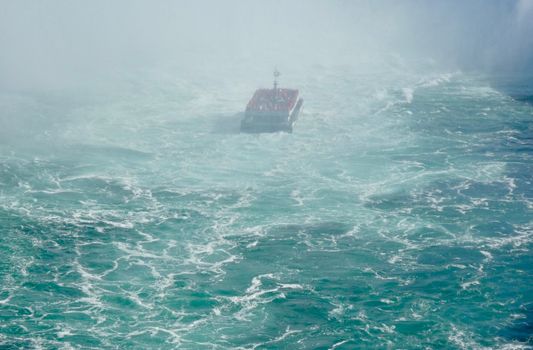 A boat navigates the misty waters near Niagara Falls, creating an adventurous scene.