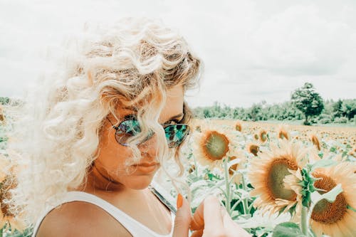 Free Woman Wearing Sunglasses on Sunflower Field Stock Photo