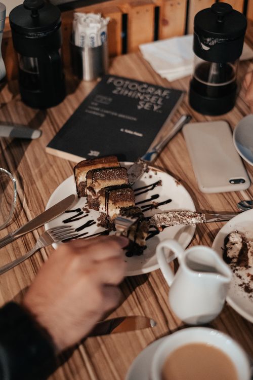 Free Close-up of a chocolate cake slice being cut in a warm coffee shop environment. Stock Photo