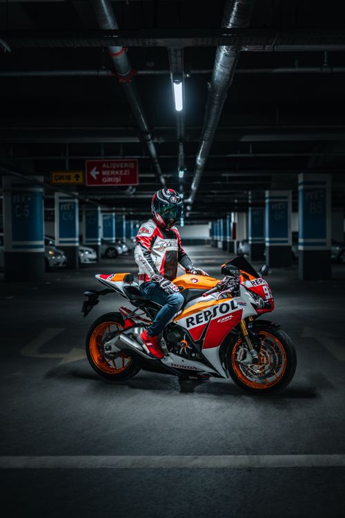 Free Rider on a sports bike posing in a dimly lit parking garage. Stock Photo