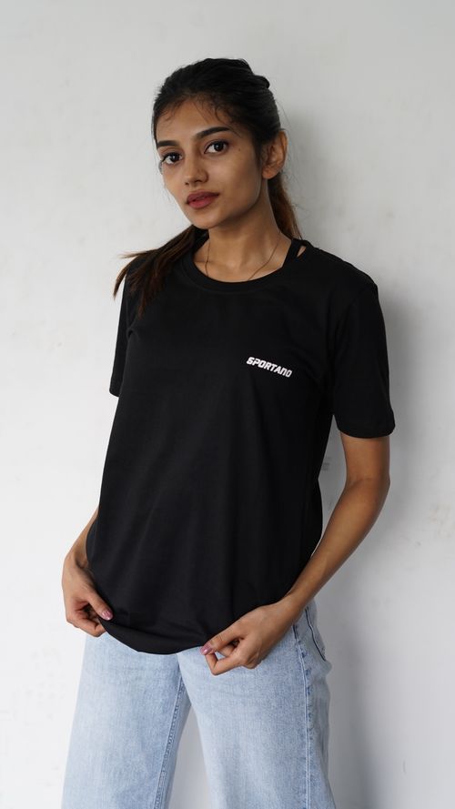 Free Fashionable portrait of a woman standing indoors wearing a black t-shirt and jeans. Stock Photo
