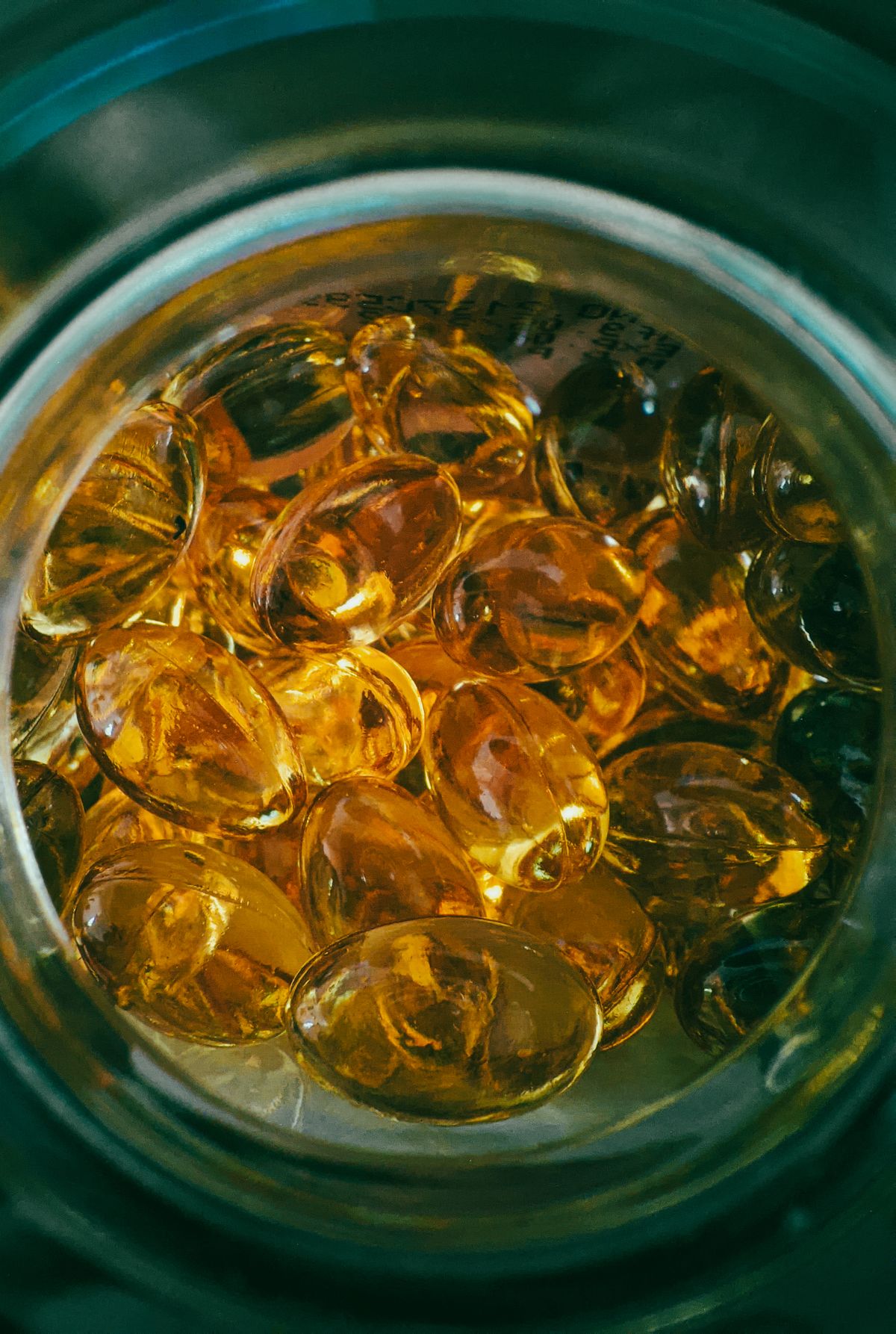Close-up of golden gel capsules in an open jar representing NAD-boosting supplements