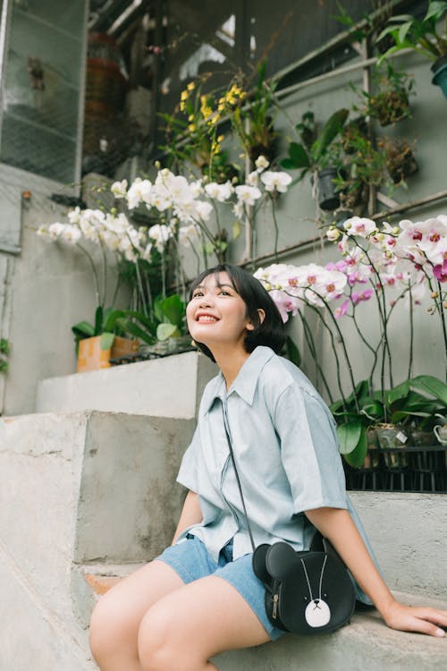 Photo of Woman Sitting near Flowering Plants