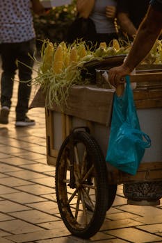 A street vendor pushing a cart full of fresh corn on a bustling Istanbul street.