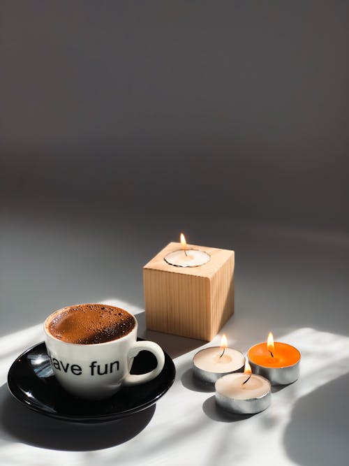 Coffee in Cup and Candles on White Background