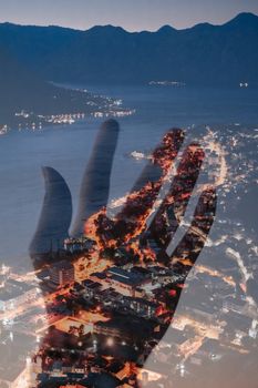 A creative double exposure of a hand superimposed on a vibrant cityscape at night, showcasing urban life.