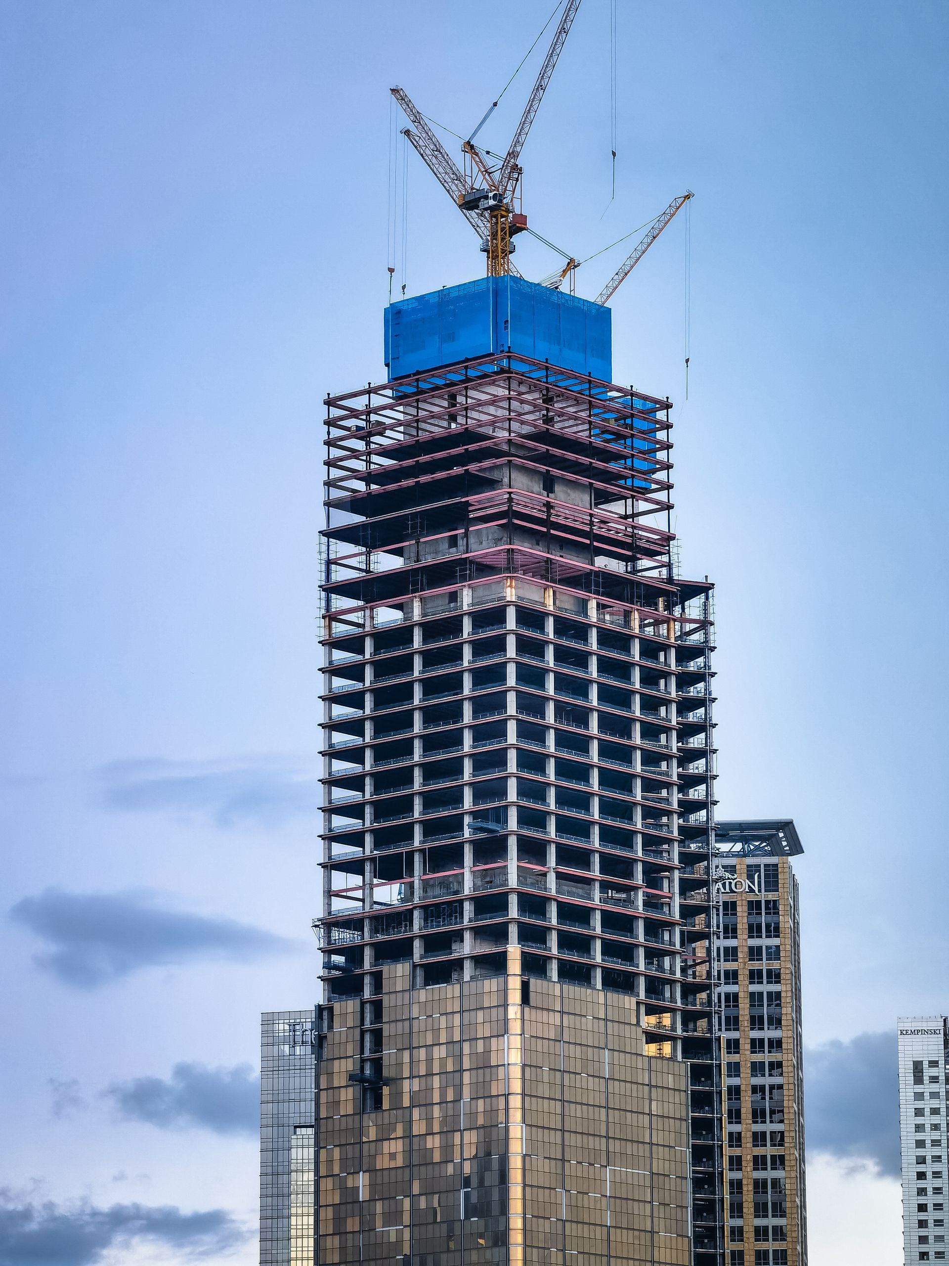 High-rise tower under construction with cranes