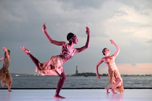 grátis Três Mulheres Dançando Perto De Um Corpo D'água Foto profissional