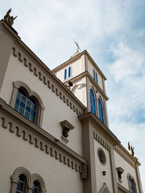 Free Charming architectural details of a church tower under a bright blue sky. Stock Photo