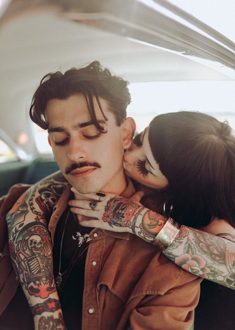 A Tattooed Woman Kissing A Woman