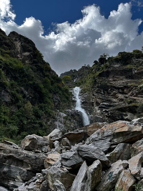 Waterfalls Between Green and Brown Mountain Under Blue Sky and White Clouds