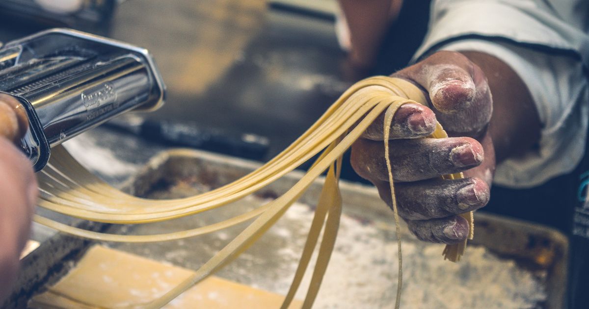 Persoană făcând paste proaspete tagliatelle cu mâna