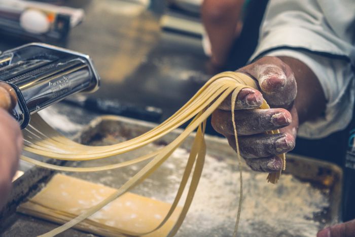 Hands rolling fresh pasta dough