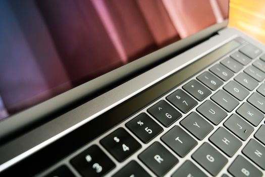 Detailed close-up of a sleek, modern laptop keyboard with a reflective screen, emphasizing technology and design.