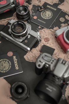 Flat lay of travel essentials including cameras, a map, and Mexican passports.