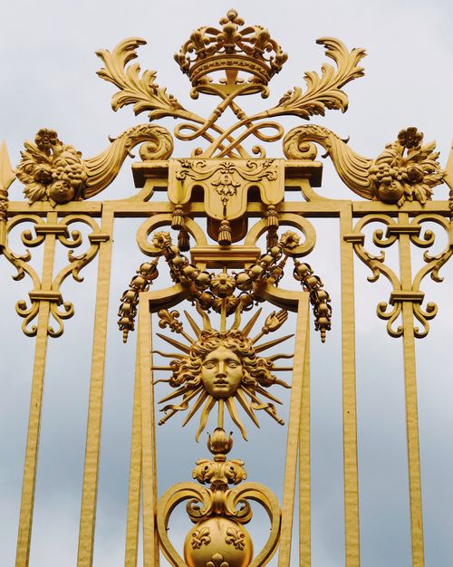 Free Close-up of an ornate golden gate with regal motifs at Versailles Palace, France. Stock Photo
