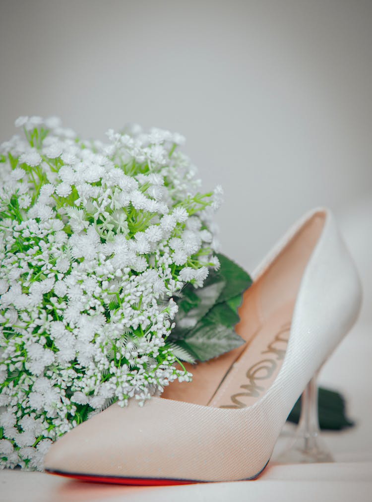 White Flowers Beside White Wedding Shoe