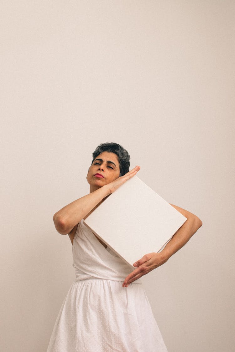 Mature Woman In White Dress Holding Square