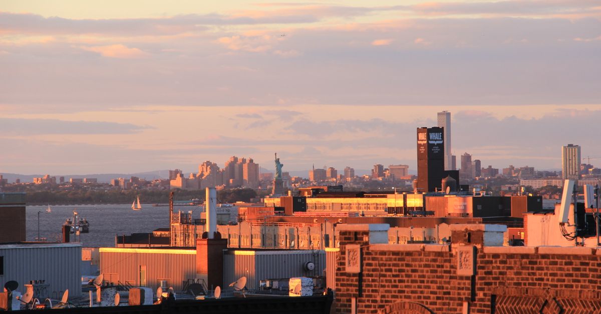A stunning sunset view of New York City skyline featuring the Statue of Liberty, perfect for travel and urban themes.