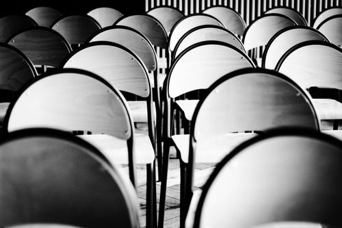 Free A striking black and white photo of empty chairs in a row, creating a sense of emptiness and calm. Stock Photo