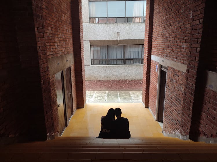 A Couple Sitting On Stair Steps 