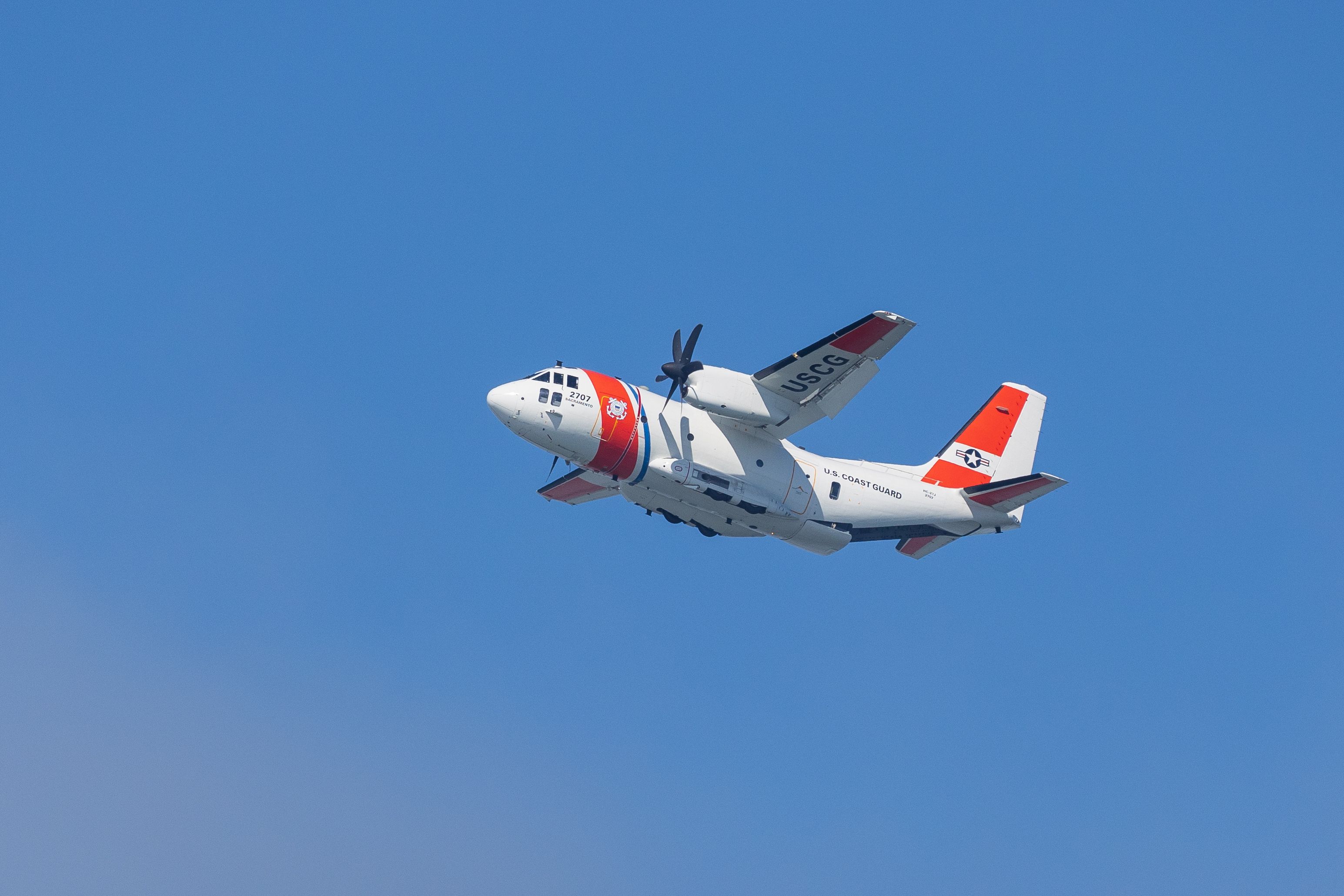 Aircraft flies through a clear blue sky