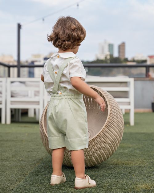 Free Cute toddler in light green outfit playing with a large textured ball on a sunny day outdoors. Stock Photo