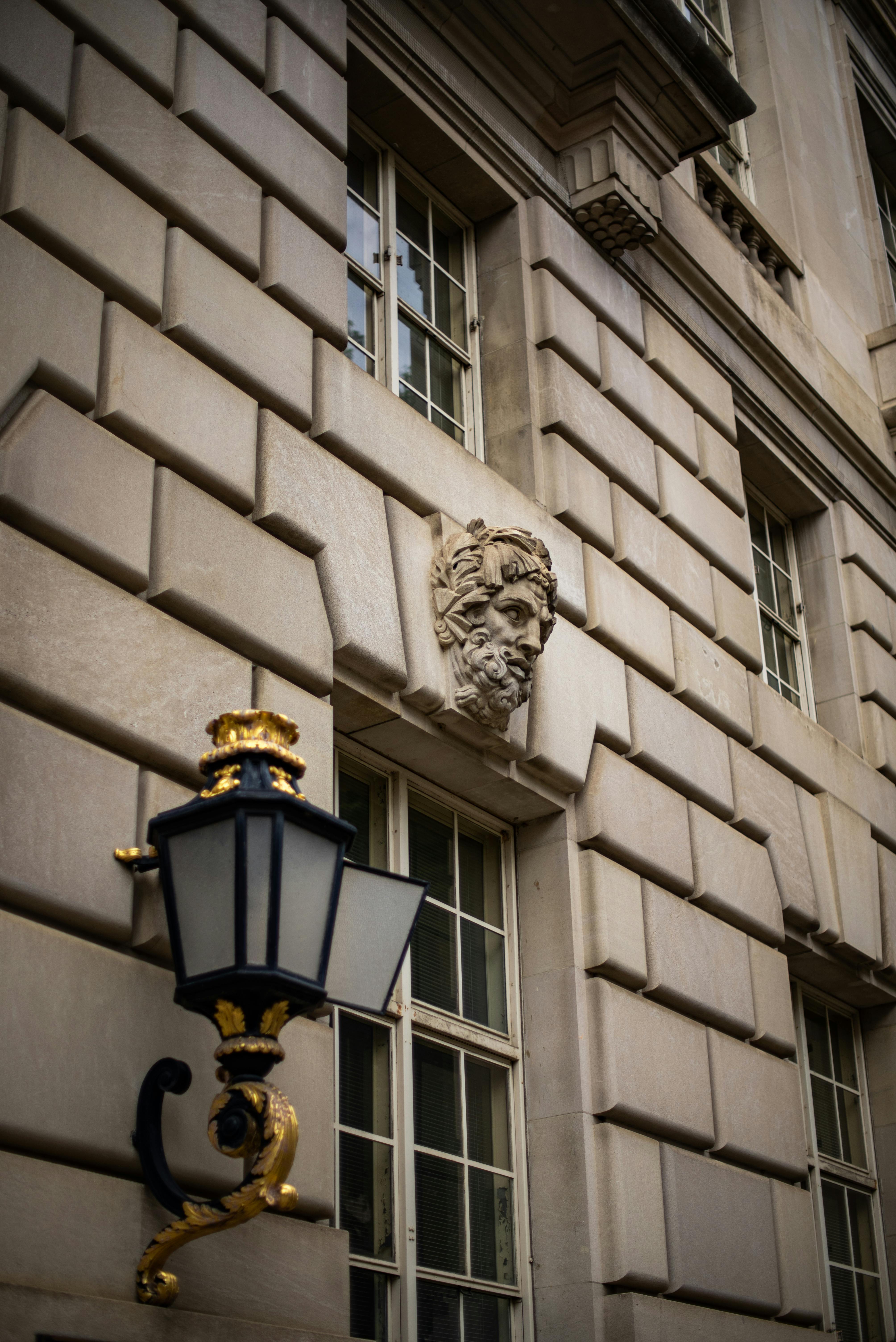 Elegant stone facade in Washington DC, featuring intricate bas-relief and classic lamp.