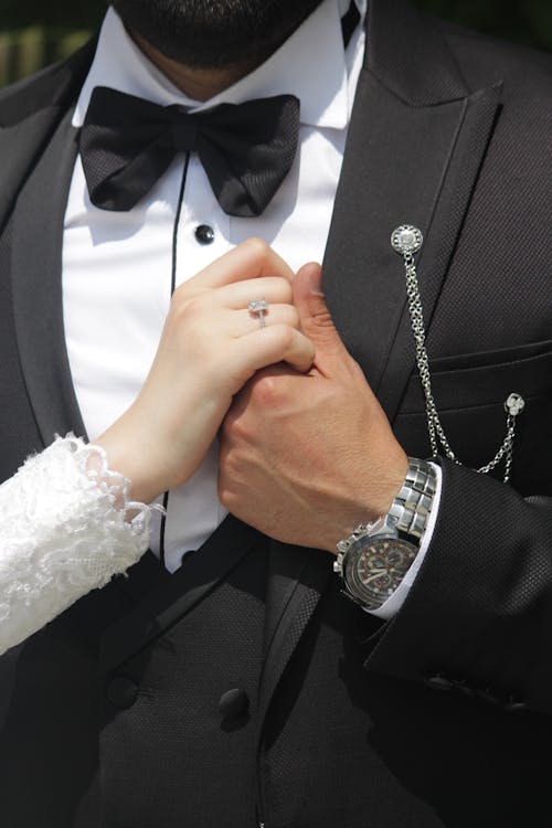 A Man in Black Suit Jacket Holding a Woman in White Wedding Dress