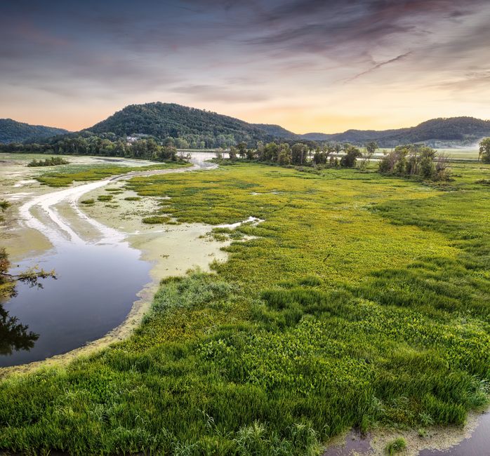 Captivating view of tranquil wetlands and lush hills during sunset in Alma, Wisconsin.