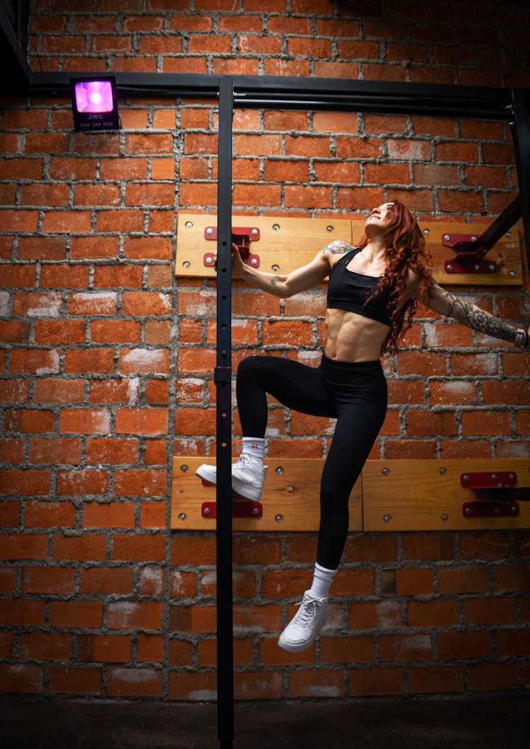 Fit Woman Hanging On A Pole 