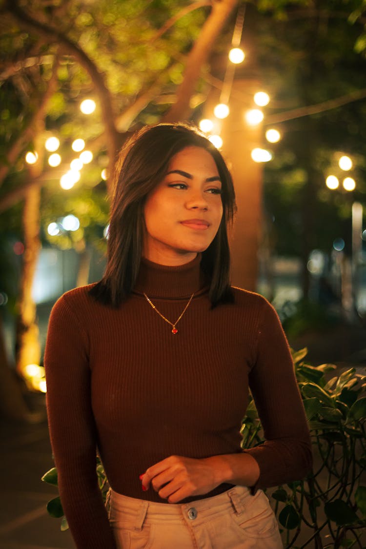 A Woman Wearing A Sweater And Necklace 