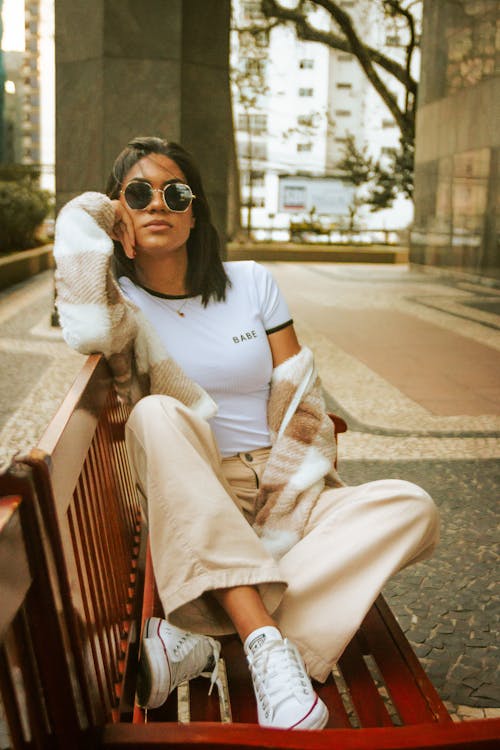 A Woman Sitting on the Bench Wearing Sunglasses 
