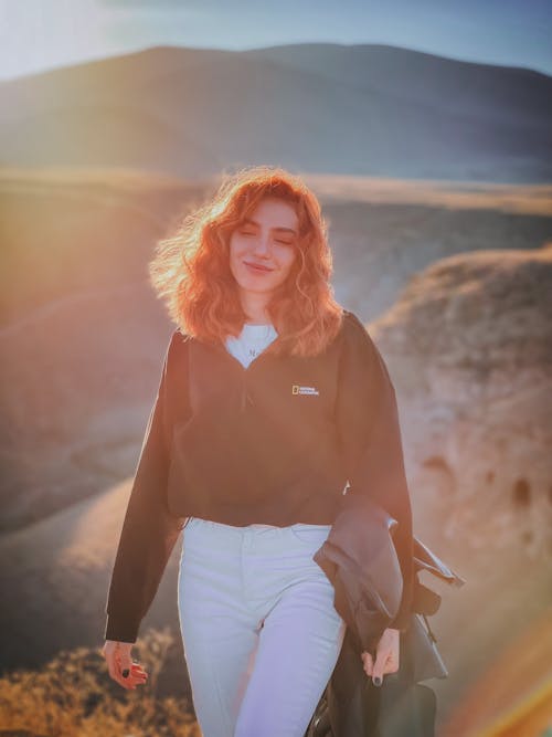 A Portrait of a Woman Wearing a Black Jacket and White Pants